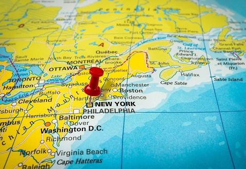 Red thumbtack in a map pushpin pointing at New York city